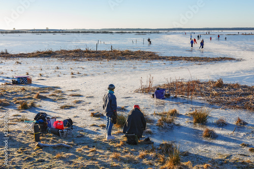 Fototapeta Women on the way to skating on a lake