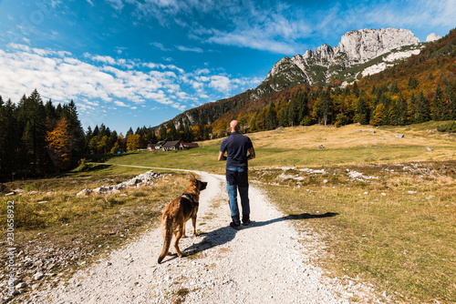 Man walking with dog in high mountains photo