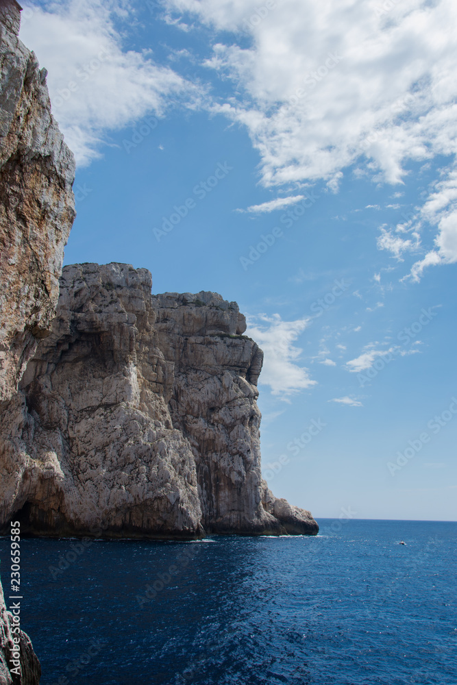 Scogliera altissima a picco sul mare in Sardegna vista dal sentiero che porta alla grotta di Nettuno