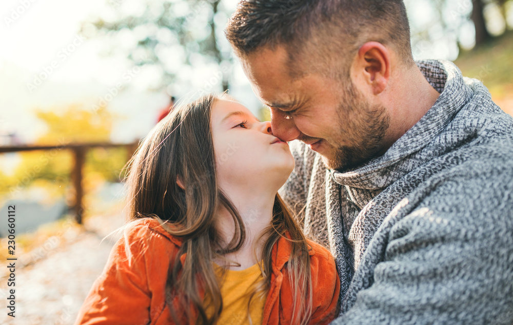 A young father having fun with a small daughter in autumn nature. A young father having fun with a small daughter in autumn nature.