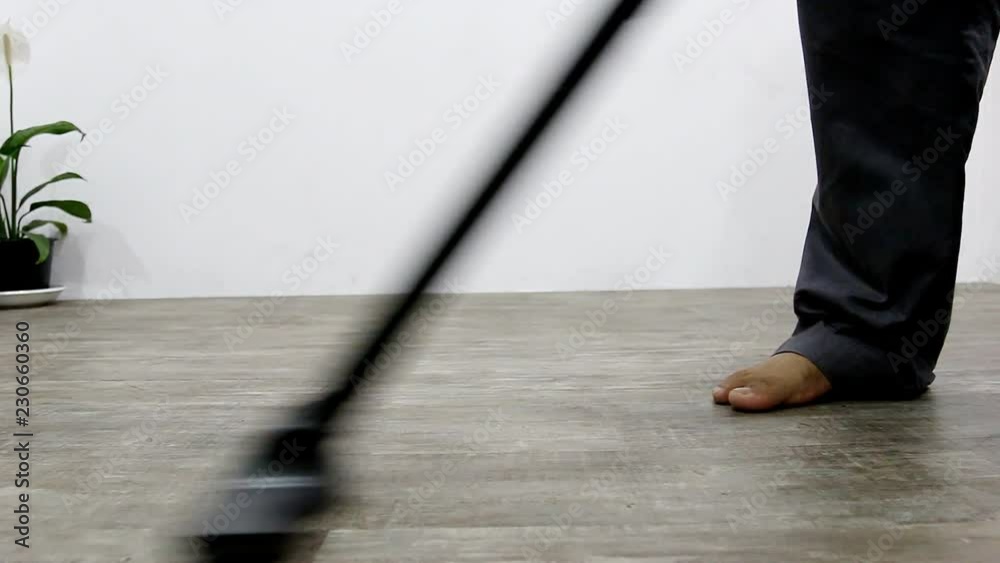 Man cleaning hardwood floor with vacuum cleaner Man cleaning hardwood floor with vacuum cleaner