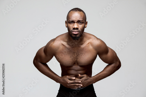 Pain concept. Beautiful male portrait isolated on pink backgroud. Young emotional surprised man looking at camera.Human emotions, facial expression concept. man overwhelmed with pain in stomach