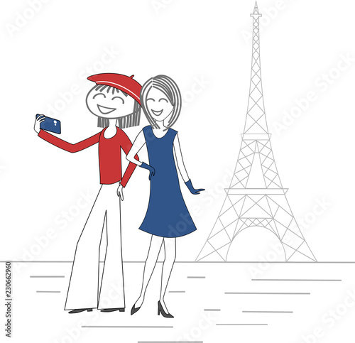 Two women take pictures of themselves with a mobile phone in Paris in front of the Eiffel Tower