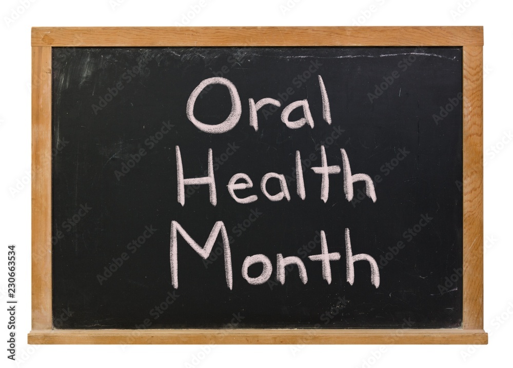 Oral Health Month written in white chalk on a black chalkboard isolated on white Oral Health Month written in white chalk on a black chalkboard isolated on white