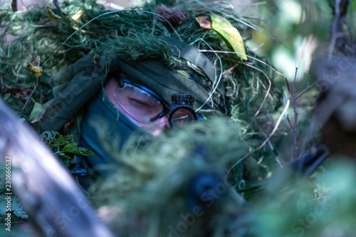 special forces, soldier assault rifle with silencer, optical sight. behind cover waiting in ambush photo