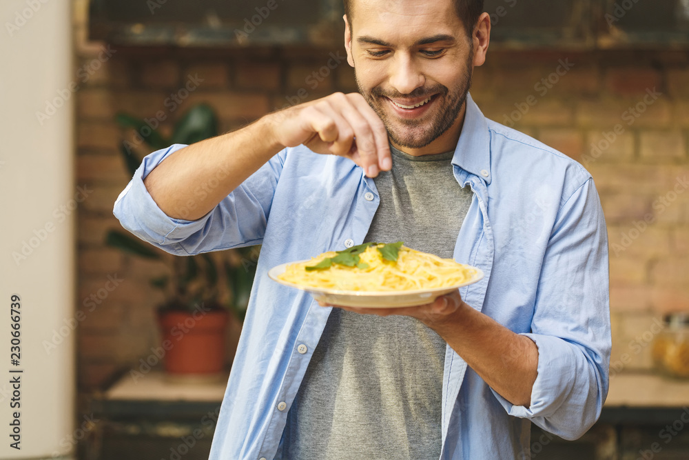Close-uo of young man preparing delicious and healthy food in the home kitchen on a sunny day. Close-uo of young man preparing delicious and healthy food in the home kitchen on a sunny day.