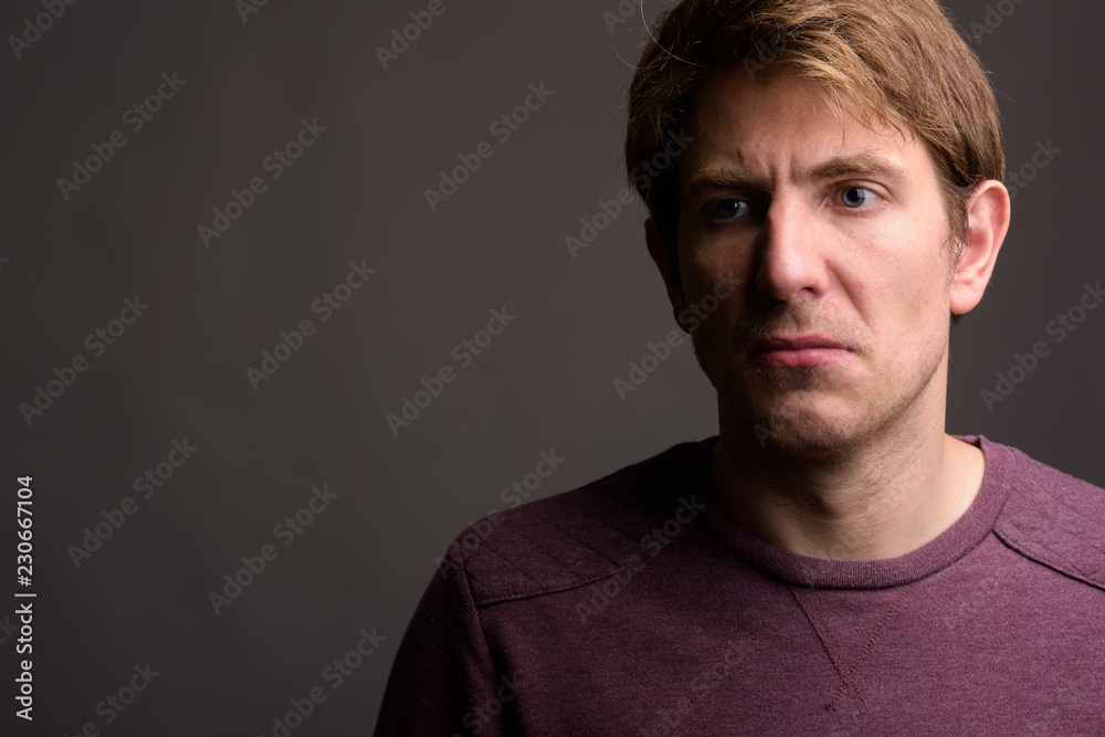 Fototapeta premium Portrait of handsome man against gray background