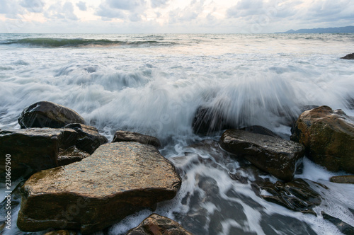 Seascape with waves hitting the stones, sunset