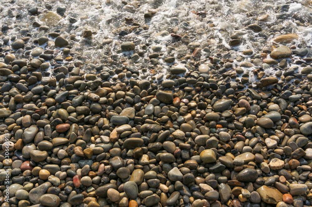 Waves washing small stones, top view Waves washing small stones, top view