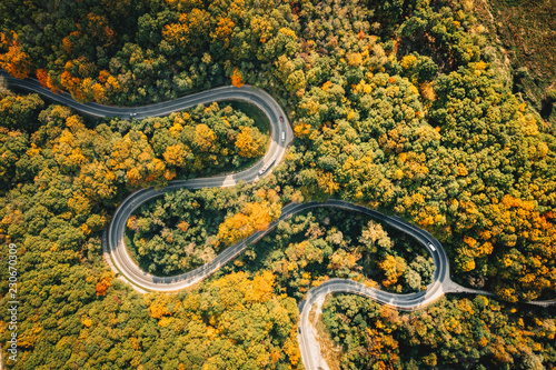 Road seen from above. Aerial view of an extreme winding curved road in the middle of the forest