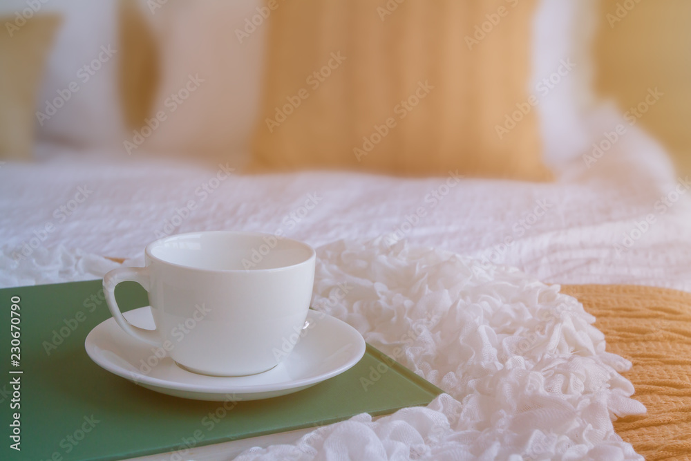 White coffee cup put on green plate in the bed room and window lighting. Background process by sunlight effect as a morning. Selective focus and copy space