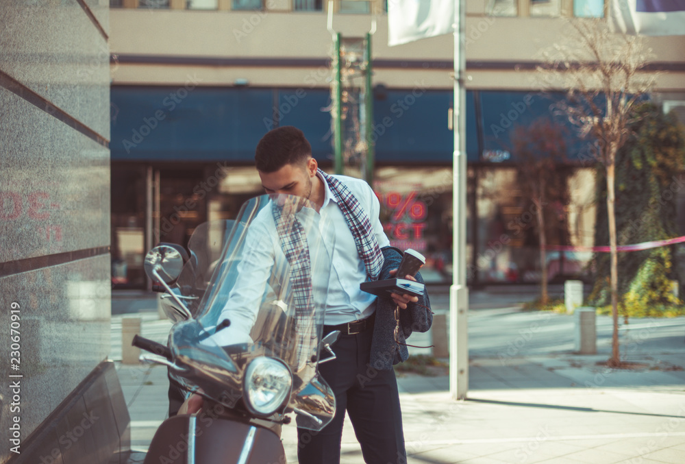 Obraz premium Urban businessman looking in the motorcycle