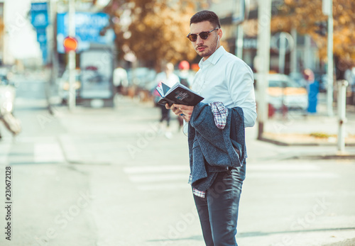 Young businessman standing on the street, looking front