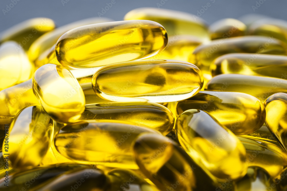 Omega 3 Gelatin Capsules Scattered On A Gray Slate Background. Fish Oil, Vitamins, Pills. Medical Series. Close Up. Macro. Angle View. Omega 3 Gelatin Capsules Scattered On A Gray Slate Background. Fish Oil, Vitamins, Pills. Medical Series. Close Up. Macro. Angle View.