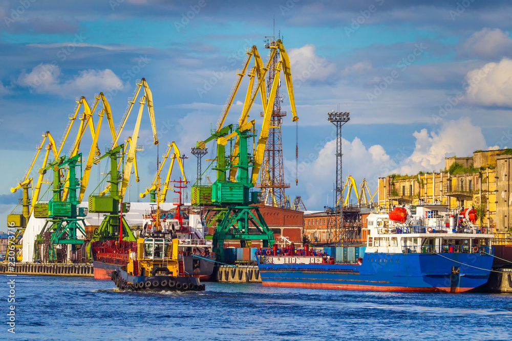 Naklejka premium Berth port. Unloading ships. Cranes unload ships. Merchant navy.