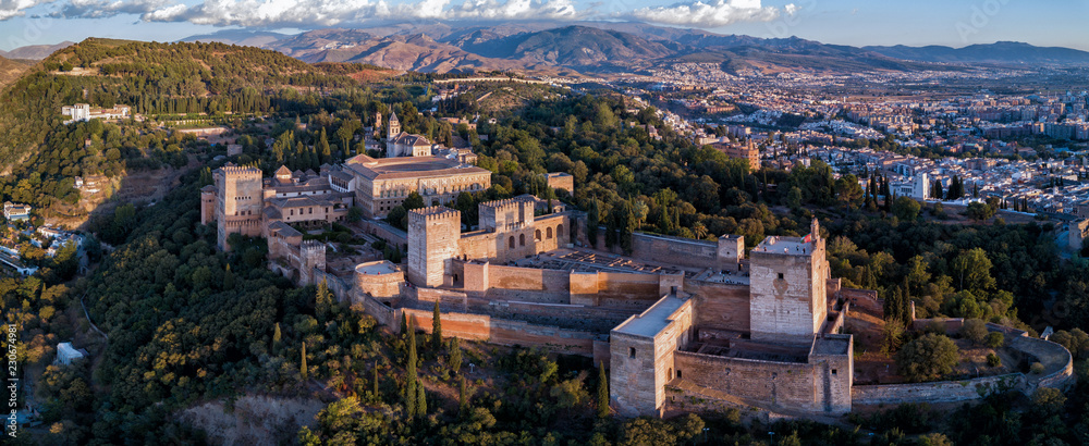 Aerial drone panorama photo of The Alhambra Palace of Granada Spain at sunset.  Vast fortress castle complex overlooking Granada, built by the Moorish Empire.  