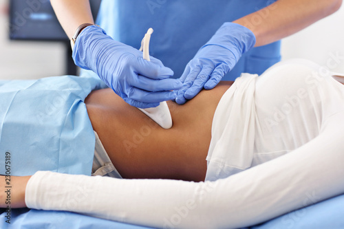 Adult woman having abdomen ultrasound tests at female doctor s office