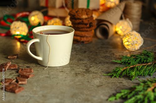 tea in a white cup  tea bag  gifts on the table. holiday atmosphere. top image. food background