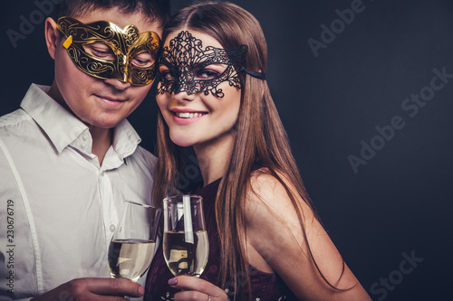 Couple celebrating New Year's eve drinking champagne on masquerade party © maryviolet