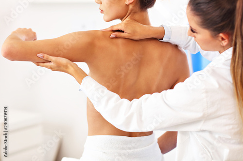 Female physiotherapist helping a patient with back problems in clinic