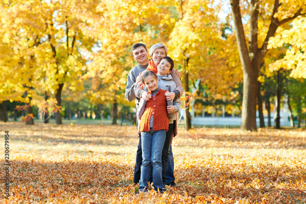 Happy family walks in autumn city park. Children and parents posing, smiling, playing and having fun. Bright yellow trees. Happy family walks in autumn city park. Children and parents posing, smiling, playing and having fun. Bright yellow trees.