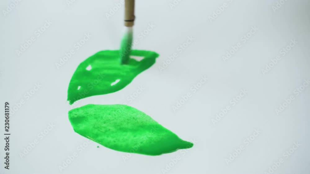 The girl draws forms of green paint