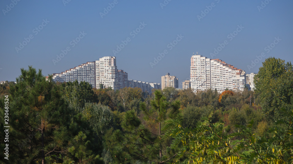 Views of the city of Chisinau on the horizon. White beautiful house among the green trees.
