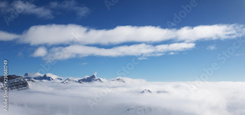 Panoramic view on sunlight mountains under clouds