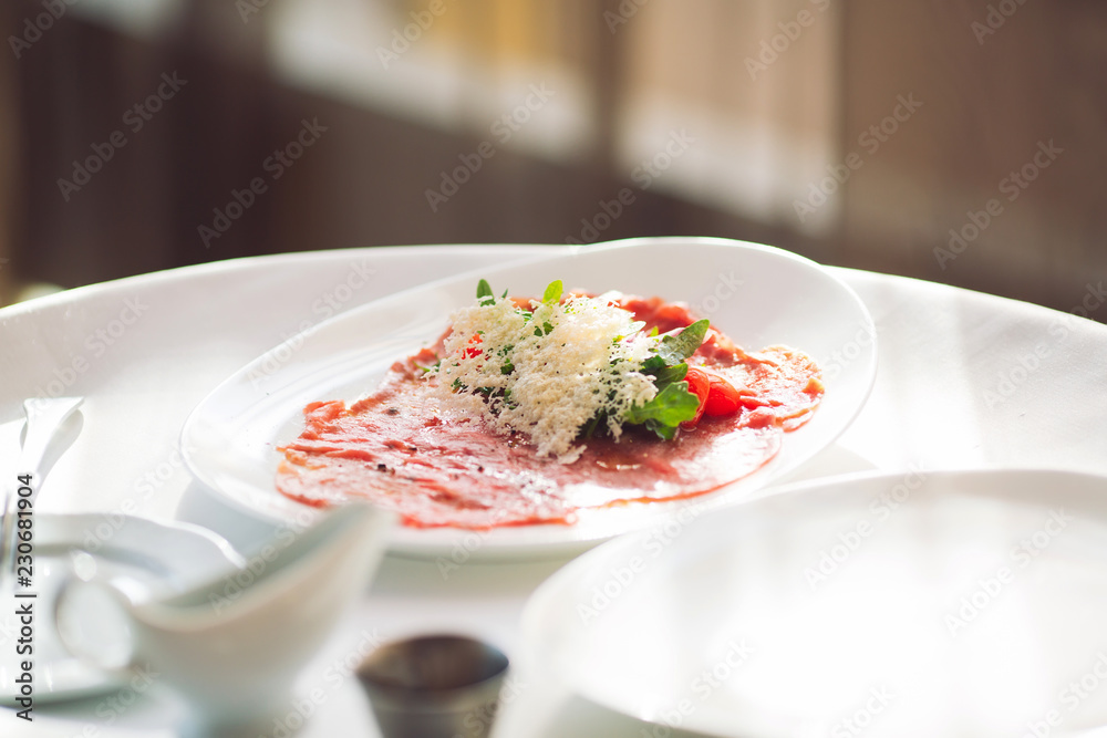 Red beef carpaccio in a white plate