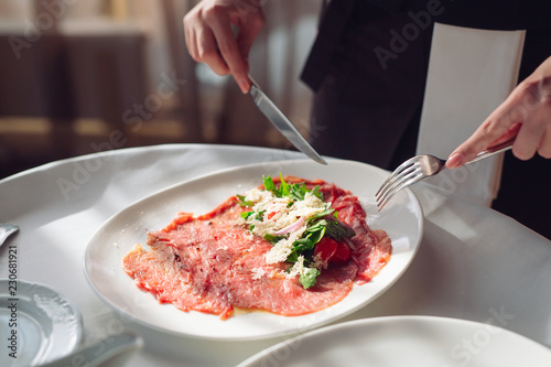 Red beef carpaccio in a white plate,