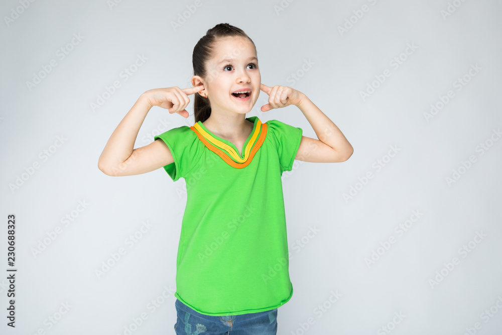 Girl on a gray background covered with your fingers. Girl on a gray background covered with your fingers.