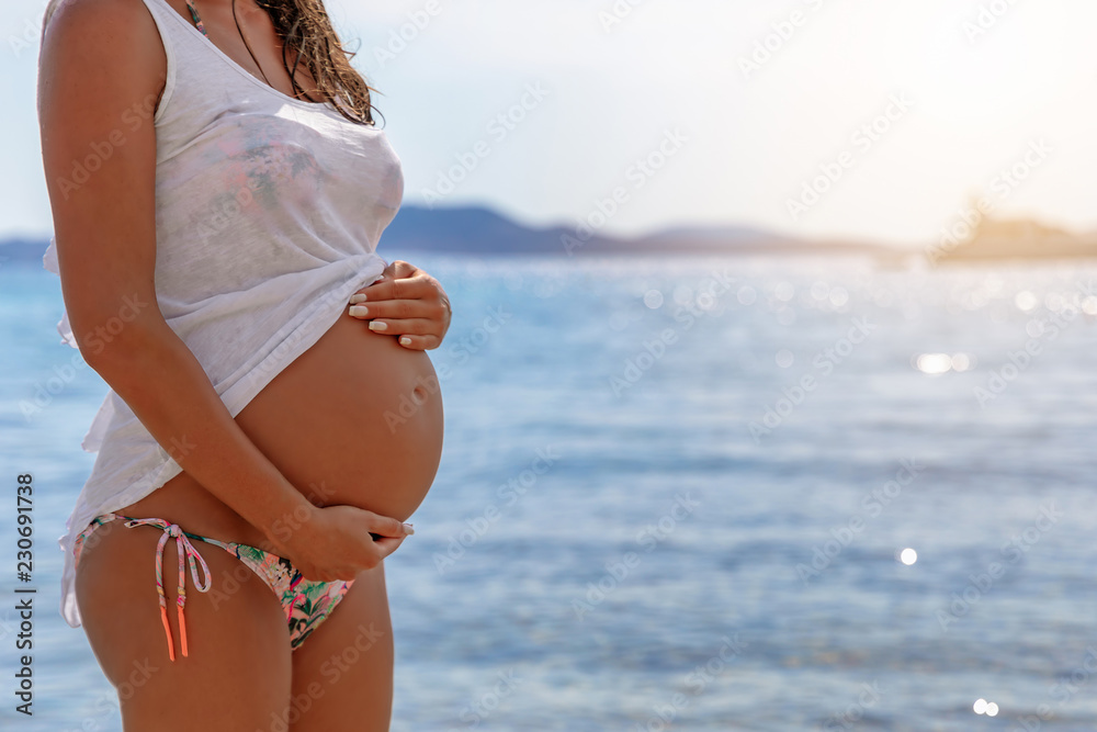 Schwanger im Urlaub: Schwangere Frau im Bikini vor blauem Meer Stock Photo  | Adobe Stock