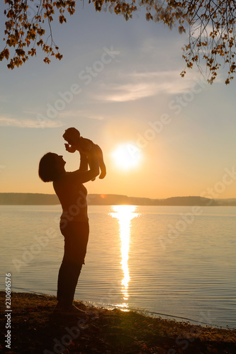 Mom and daughter are on the beach at sunset