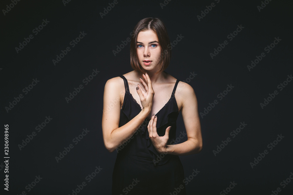 Portrait of a beautiful young Caucasian Caucasian woman 20 years old model with blue eyes natural make-up of hair on shoulder dancing hands posing on black isolated background in black lingerie Portrait of a beautiful young Caucasian Caucasian woman 20 years old model with blue eyes natural make-up of hair on shoulder dancing hands posing on black isolated background in black lingerie