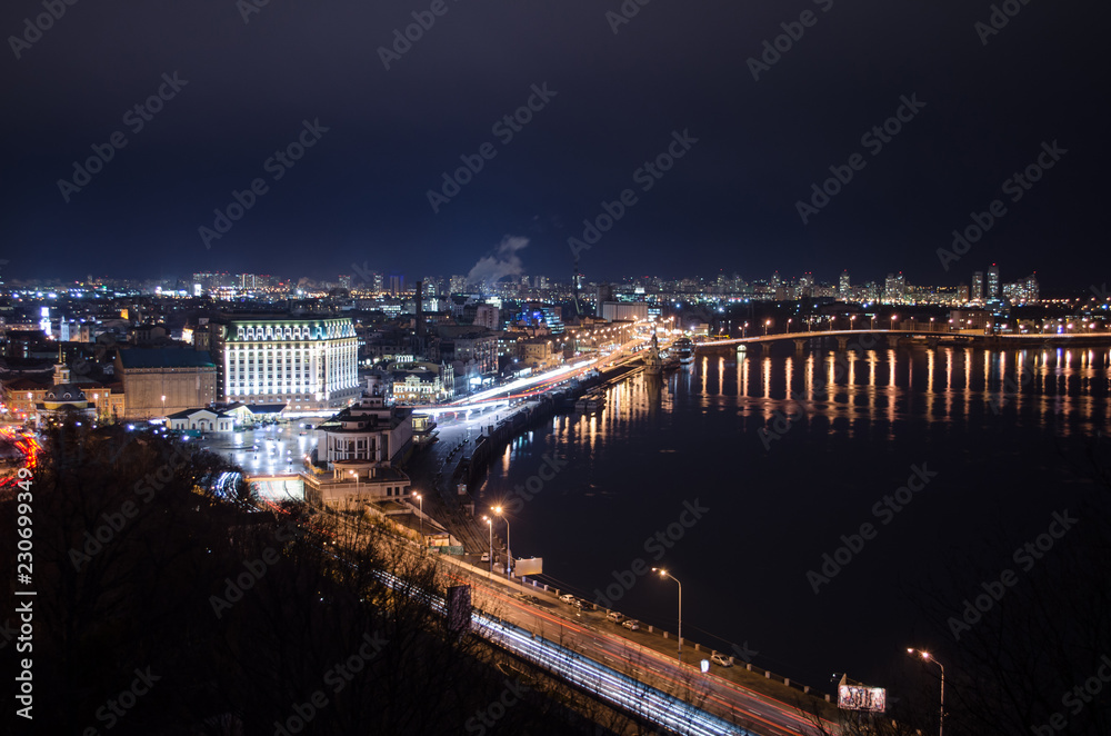 Panorama of night city landscape with river and bridge. Reflection of glowing lanterns in water. Panorama of night city landscape with river and bridge. Reflection of glowing lanterns in water.