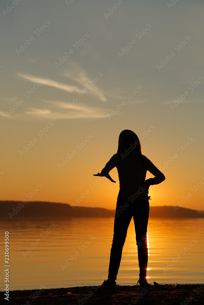 Girl at sunset on the beach engaged in fitness