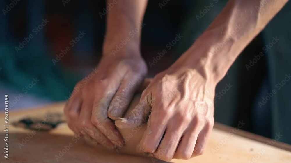 Pottery and ceramic. Sculptor is pugging and kneading clay on table Pottery and ceramic. Sculptor is pugging and kneading clay on table