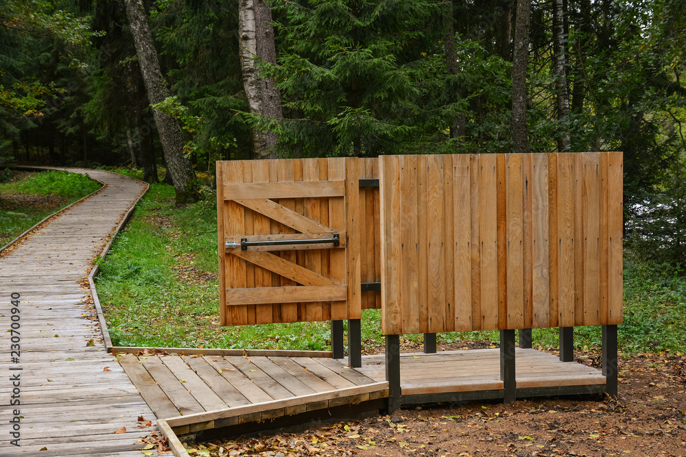 Wooden beach cloakroom in recreation area of forest park near lake. Autumn day. Wooden beach cloakroom in recreation area of forest park near lake. Autumn day.