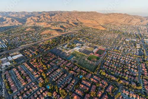 Aerial view of modern suburban housing, the 118 freeway and Rocky Peak Mountain Park near Los Angeles in Simi Valley, California.