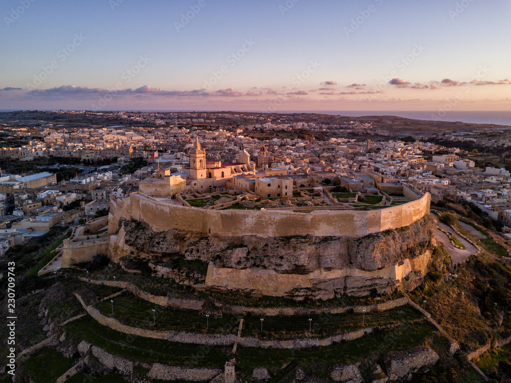 Aerial drone photo - The Gozo Citadel at sunset. A medieval fortress in the city of Victoria (Rabat). Island of Gozo, Malta.