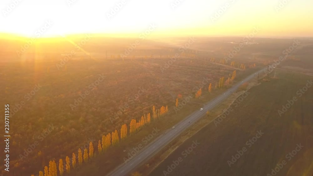 Aerial: fly cam follow motorbike on the road at sunset time
