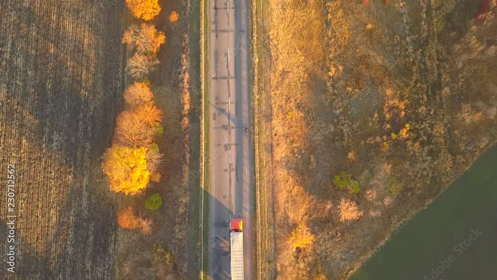 Aerial: fly cam follow motorbike on the road at sunset time