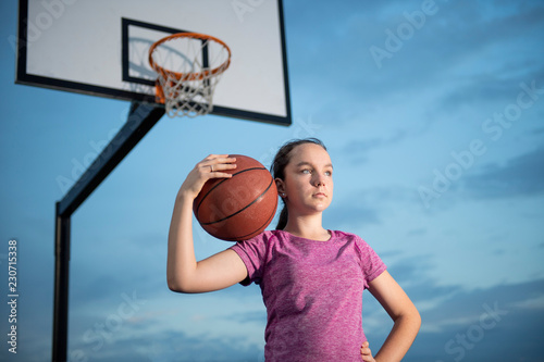 Girl holding a basketball at an outdoor court © scottdavis2