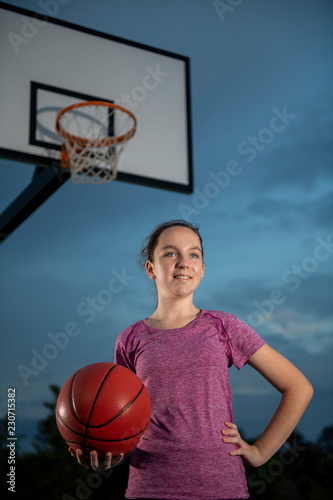 Girl holding a basketball at an outdoor court © scottdavis2
