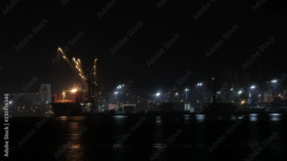 Container ship discharging at the port at night, port of novorossiysk, unmoored ship go out of the port 30.10.2018, timelaps Container ship discharging at the port at night, port of novorossiysk, unmoored ship go out of the port 30.10.2018, timelaps