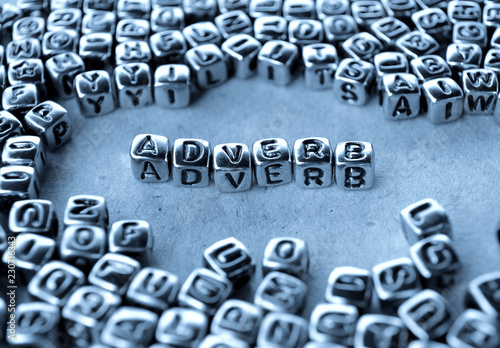 Adverb - Word from Metal Blocks on Paper - Concept Photo on Table
