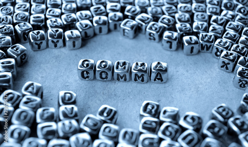 Comma - Word from Metal Blocks on Paper - Concept Photo on Table
