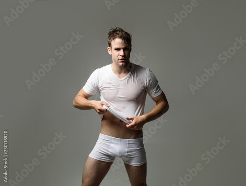 Strong athletic man in underwear. Sexy erotic handsome man in wet t-shirt.  Sensual man in underwear. Muscular male model in white underwear. Men's  swimwear and underwear. Man in boxer shorts. Fashion. Stock