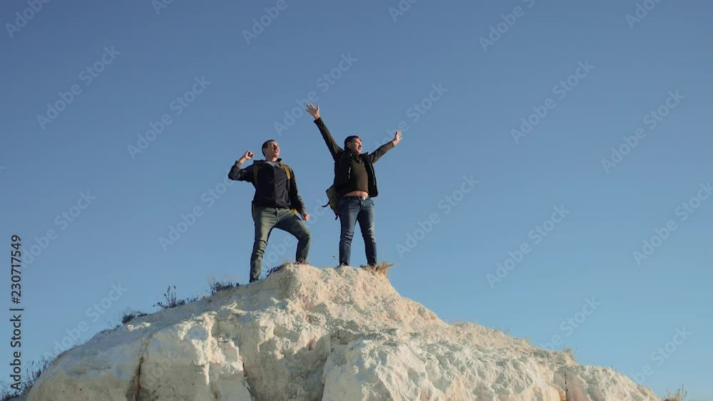 two men tourists hiking adventure climbers climb the mountain success hand to hand freedom up. slow motion video. hiker walking goes on nature on the hill white rock. extreme outdoor activity sport two men tourists hiking adventure climbers climb the mountain success hand to hand freedom up. slow motion video. hiker walking goes on nature on the hill white rock. extreme outdoor activity sport