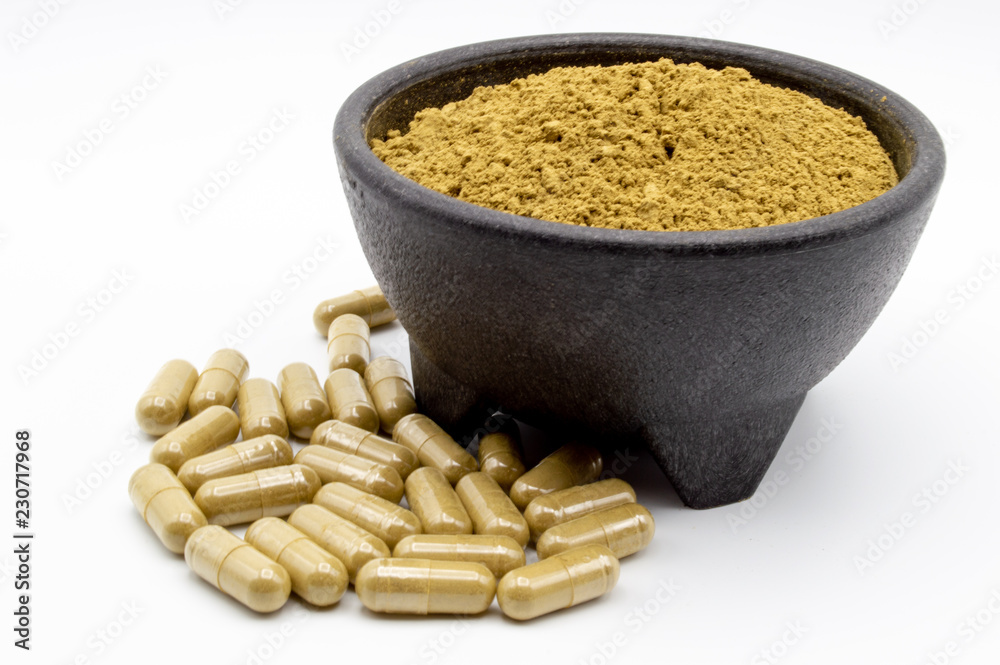 Kratom powder in bowl with capsules along side